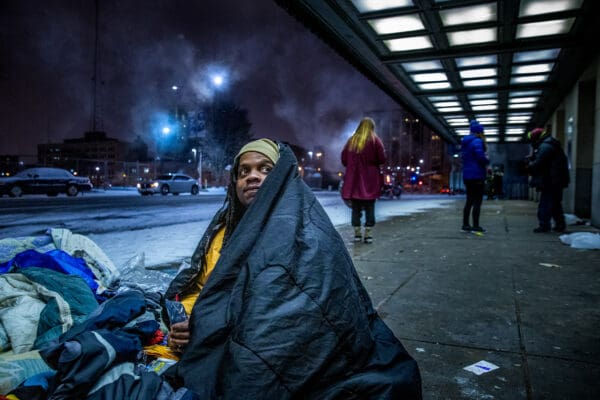 Lisa Johnston | lisajohnston@archstl.org | twitter: @aeternusphoto

Quinn Brown has been homeless on and off for the past two years. A former chef, Brown says the only way out of homelessness is a job and support system. He huddled with other men outside of the Enterprise Center under blankets over the heat exhaust vent to keep warm on Jan. 30, 2019.  

As temperatures dropped to near 0 degrees, students from St. Louis Univerisity's LABRE organization acted to invite homeless off the street and house them on SLU property.  

LABRE students prepare sack dinners each week and brings them to homeless people living on the streets near their campus. Their mission states that the food is an excuse to have a conversation with their neighbors.