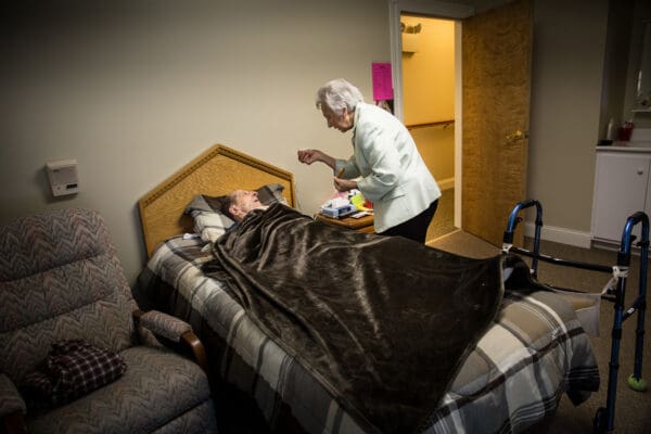 Lisa Johnston | lisajohnston@archstl.org  | Twitter: @aeternusphoto Mary Ann Huber distributes the Eucharist every Wednesday and Sunday to those who wish to receive the sacrament at her assisted living center. She gave Tony Campisi Holy Eucharist while he was in his bed.  Mary Ann Huber began her mission to serve the elderly in 1981 and with the help of her husband William, she began Twin Oaks Estate with her first 12 elderly residents. Located on seven wooded acres in O'Fallon, the site now has room for 149 residents.  Huber can be found doing whatever needs to be done at the center where her mission is to serve the residents physically, mentally and spiritually.